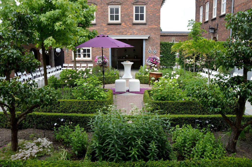 De klassieke binnentuin met buxushagen, klaargezet voor een ceremonie